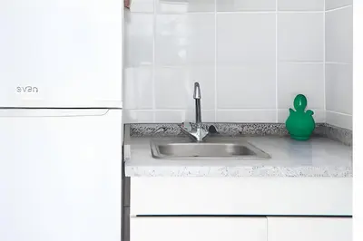 a kitchen sink with a green detergent next to it at Studio Faria Guimaraes in Porto