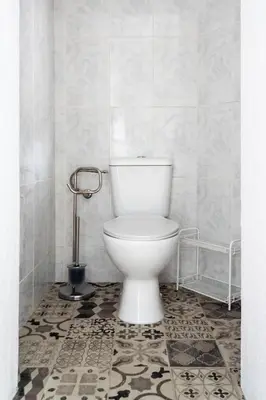 a white toilet in a bathroom with a tile floor at Studio Faria Guimaraes in Porto