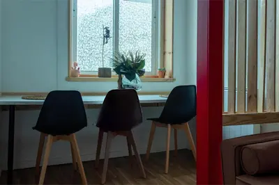 a table with three chairs in front of a window at Studios Faria Guimaraes in Porto