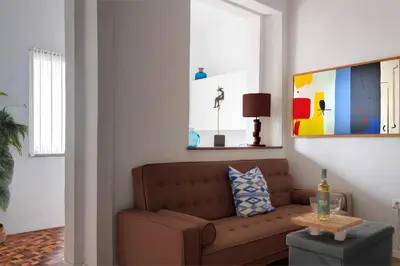 a living room with a brown couch and a table at Studios Faria Guimaraes in Porto