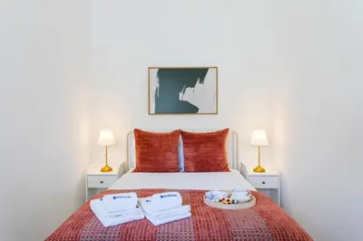 a bedroom with a bed with a plate of food on it at Bright Flat | Romantic Escape by HostWise in Porto