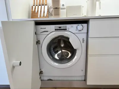 a washing machine under a counter in a kitchen at AC, 2Bedrooms APT, City Center 900m to Metro in Porto