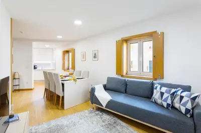 a living room with a blue couch and a table at Modern & Central Flat w/ Garage by HostWise in Porto