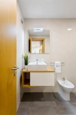 a bathroom with a sink and a toilet and a mirror at Modern & Central Flat w/ Garage by HostWise in Porto