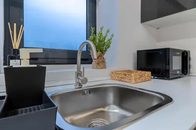 a kitchen counter with a sink and a microwave at Lapa 4 House in Porto