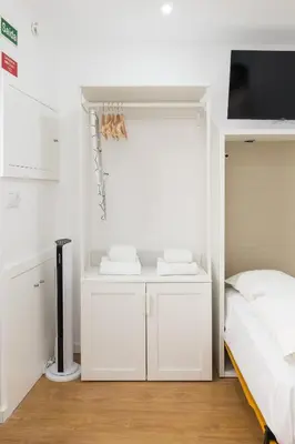 a white bedroom with a bed and a tv at Cozy Studios Porto Sao Lazaro in Porto