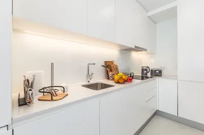 a kitchen with white cabinets and a sink at Urban Oasis Six Suites Apts Porto in Porto