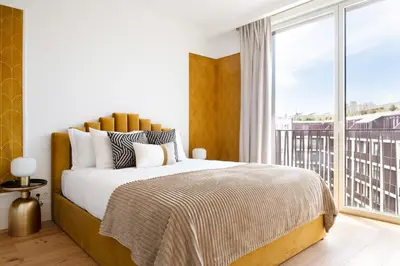 a bedroom with a large bed and a large window at Sa Bandeira Signature Apartment in Porto