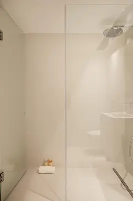 a glass shower door in a white bathroom at Sa Bandeira Signature Apartment in Porto