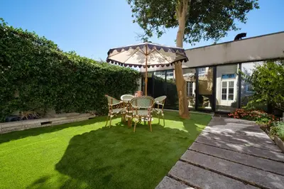 a table and chairs on a lawn with an umbrella at Garden Luxury House Downtown Oporto with AC in Porto