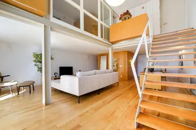 a living room with a white couch and a staircase at Garden Luxury House Downtown Oporto with AC in Porto