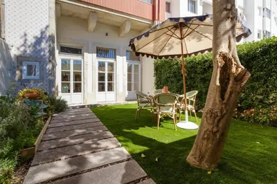 a patio with a table and an umbrella at Garden Luxury House Downtown Oporto with AC in Porto