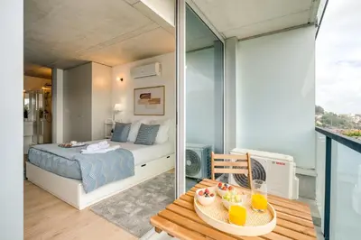 a bedroom with a bed and a table with a tray of fruit on it at Premium Apartments with Balcony, Pool & Garage by HostWise in Vila Nova de Gaia
