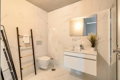 a white bathroom with a sink and a toilet at Premium Apartments with Balcony, Pool & Garage by HostWise in Vila Nova de Gaia