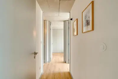 an empty hallway with white walls and wood floors at Premium Apartments with Balcony, Pool & Garage by HostWise in Vila Nova de Gaia