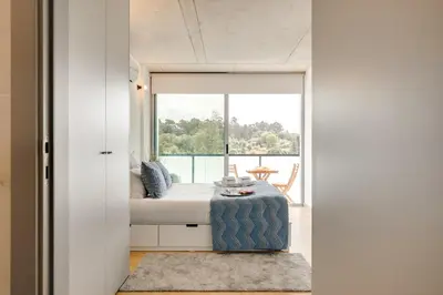 a room with a bed and a large window at Premium Apartments with Balcony, Pool & Garage by HostWise in Vila Nova de Gaia