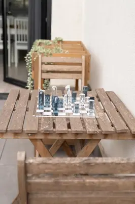 a wooden picnic table with glasses on top of it at Modern & Sleek Flat | Terrace & Garage by HostWise in Porto