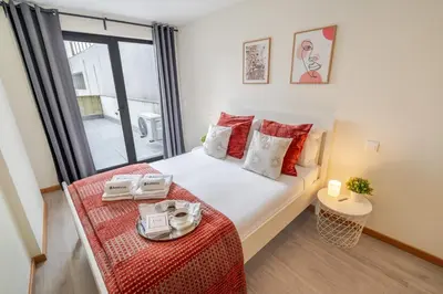 a bedroom with a bed and a large window at Modern & Sleek Flat | Terrace & Garage by HostWise in Porto