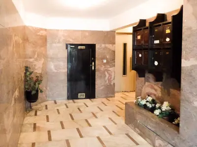 a hallway with a black door and a wooden floor at Fonsi House in Porto