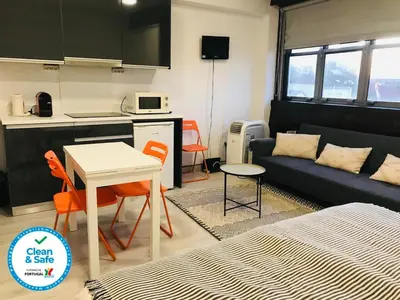 a kitchen and a living room with a couch and a table at In Love Bolhão in Porto