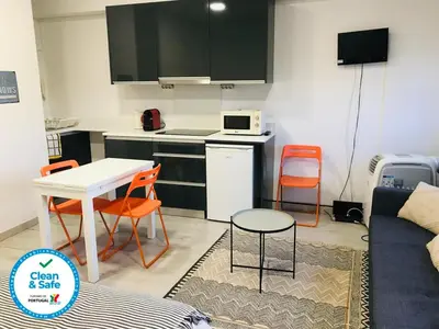 a kitchen and a living room with a table and chairs at In Love Bolhão in Porto