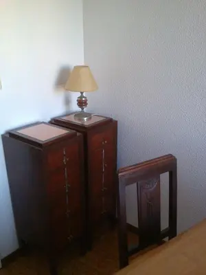 a lamp on top of a wooden cabinet next to a stool at Quiet Studio City Center in Porto
