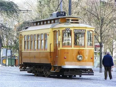 a yellow trolley car parked on a street at Quiet Studio City Center in Porto