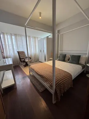 a bedroom with a canopy bed and a chair at Casa da Música Apartment in Porto