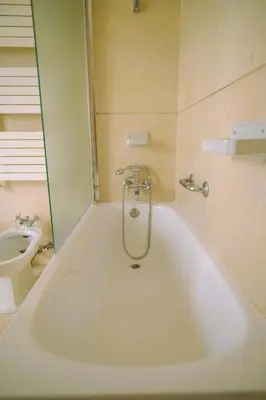 a bath tub in a bathroom with a toilet at Porto Surf Lodge in Porto