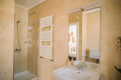 a bathroom with a sink and a shower and a mirror at Porto Surf Lodge in Porto
