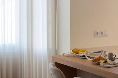 a table with a plate of food on it next to a window at Peaceful 1BR Near Metro by LovelyStay in Porto