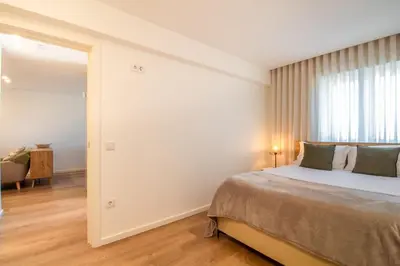 a bedroom with a large bed and a mirror at Peaceful 1BR Near Metro by LovelyStay in Porto