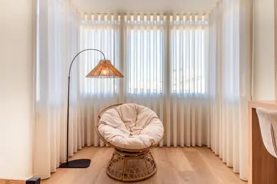 a room with a chair and a lamp and a window at Peaceful 1BR Near Metro by LovelyStay in Porto