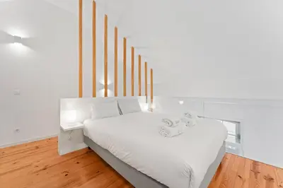 a bedroom with a white bed and a window at GuestReady - Lovely nook with mezzanine in Porto