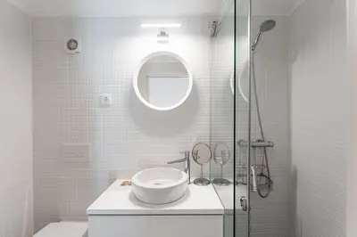 a white bathroom with a sink and a shower at GuestReady - Lovely nook with mezzanine in Porto