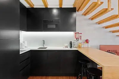 a kitchen with black cabinets and a counter top at GuestReady - Lovely nook with mezzanine in Porto