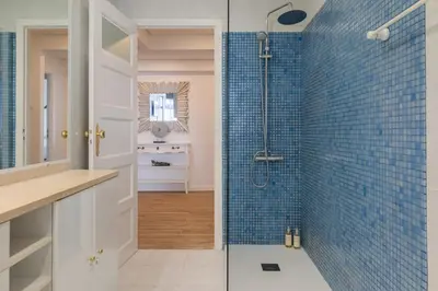 a bathroom with a shower with blue tiles at Purely Porto in Porto