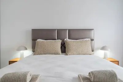 a bedroom with a large white bed with two lamps at Purely Porto in Porto