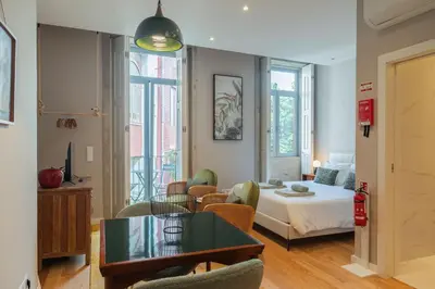 a living room with a bed and a table at Oliveirinhas Boutique Flats in Porto