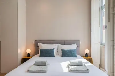 a bedroom with a large white bed with two pillows at Oliveirinhas Boutique Flats in Porto