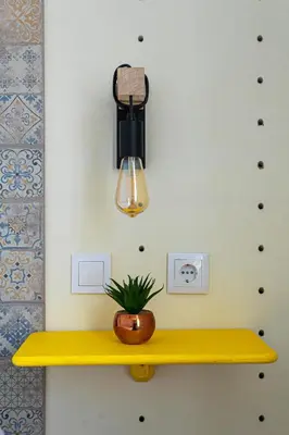 a yellow shelf with a potted plant on it at St Catarina Flats in Porto
