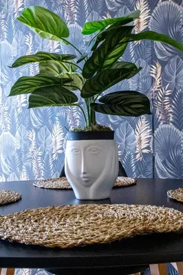 a plant in a white vase sitting on a table at St Catarina Flats in Porto