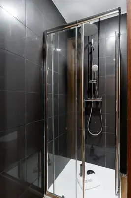 a shower with a glass door in a bathroom at GuestReady – Urban comfort in Vila Nova de Gaia in Vila Nova de Gaia