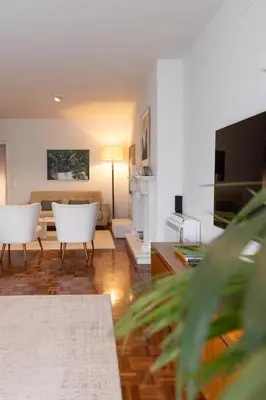 a living room with two white chairs and a couch at Porto Pátio by MP in Porto