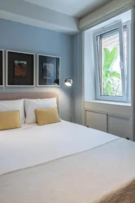 a bedroom with a large white bed with a window at Porto Pátio by MP in Porto