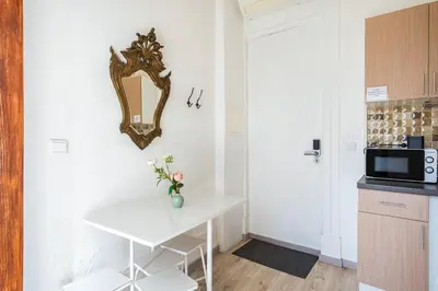 a small kitchen with a white table and a mirror at Cimo Apartments - Center Porto in Porto