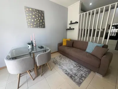 a living room with a couch and a glass table at Apartment near Porto University Campus T2 in Porto