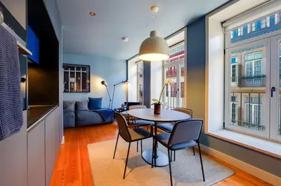 a dining room with a table and chairs and a couch at Porto Heritage Balcony Apartment in Porto