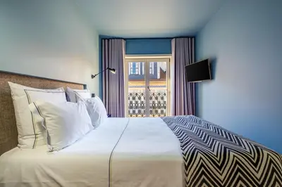 a bedroom with a large white bed and a window at Porto Heritage Balcony Apartment in Porto