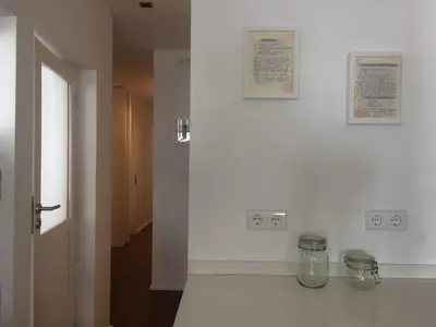 a room with a white wall with a glass vase on a counter at An apartment with a view - Nó's place in Vila Nova de Gaia